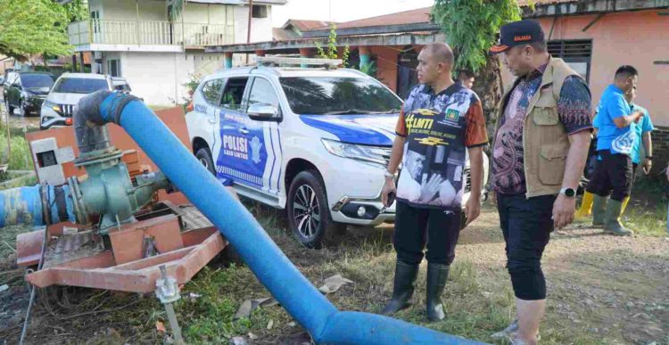 Pj Bupati Langkat, H. M. Faisal Hasrimy, meninjau lokasi banjir yang merendam puluhan rumah warga di kawasan Waduk Pekan Tanjung Pura. (Red-Dberita.id)